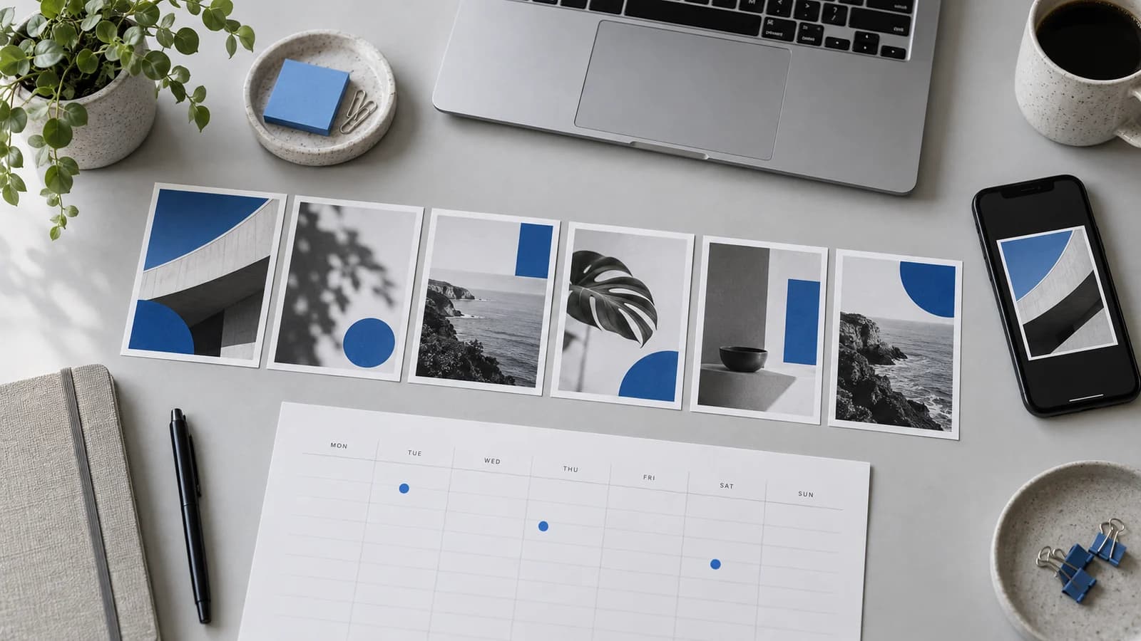 Planșe pentru un carusel, un calendar săptămânal de publicare, un laptop și un telefon pe un birou gri